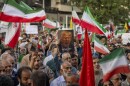 Iranian protesters chant slogans and one holds a poster with a vampire-like illustration of President Trump in Tehran's Revolution Square on Sunday to protest the U.S. attacks on nuclear sites in Iran.