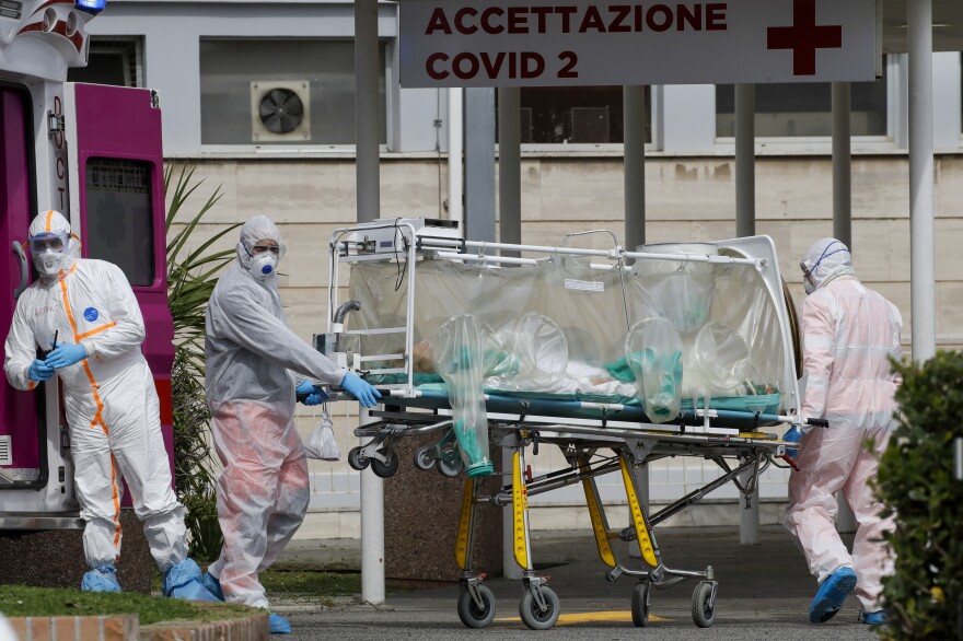 A patient in a biocontainment unit is carried on a stretcher from an ambulance at the Columbus Covid 2 Hospital in Rome, March 17.