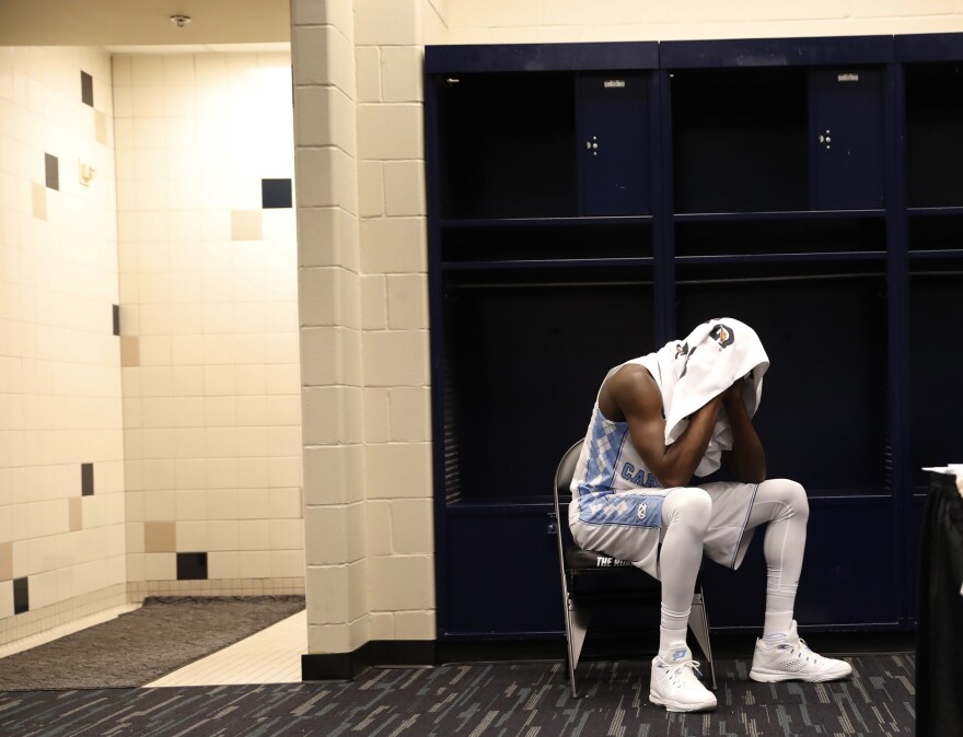 North Carolina's Theo Pinson sits in the locker room after the NCAA Final Four tournament college basketball championship game against Villanova, Monday, April 4, 2016, in Houston. Villanova won 77-74.