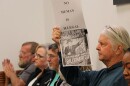 A concerned area resisdent holds up a sign during the Bradford County Commission meeting on Tuesday, April 7, 2026. (Madison Ginsberg/WUFT News)