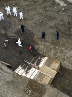 Workers wearing protective gear bury bodies in a trench on Hart Island in New York City on April 9.