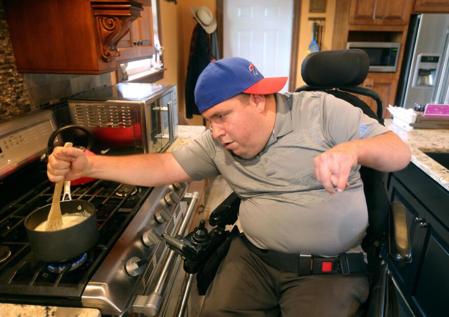 Joe stirs some soup he is reheating on the stove for lunch.