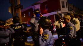 Police strap themselves into their tactical helmets before reinforcing a barricade line facing demonstrators near the location where Walter Wallace Jr. was killed by two police officers on October 27, 2020 in Philadelphia, Pennsylvania. (Mark Makela/Getty Images)