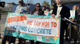 Community members hold a banner demanding officials to shutdown the Kronos Concrete facility and downzone the land where the plant operates.