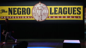 FILE - A worker passes by a display during a media tour at the Play Ball Park exhibit at the Colorado Convention Center staged by Major League Baseball as part of the festivities leading up to the All Star Game Thursday, July 8, 2021, in Denver. The convention center has been turned into a paradise for baseball aficionados complete with batting cages, an onsite home run derby, items from the Hall of Fame and countless merchandise for sale for baseball fans from far and near at the store. (AP Photo/David Zalubowski)