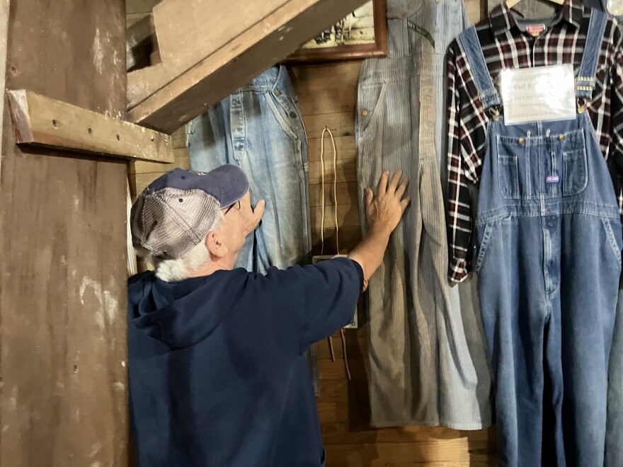 Dan Manning, one of the first two volunteers of the Fair Grove Historical & Preservation Society, shows off the "overhalls of fame" on September 12, 2024 — a display of nine denim overalls worn by key volunteers in the restoration of the 141-year-old Wommack Mill and its grounds since the late 1970s.