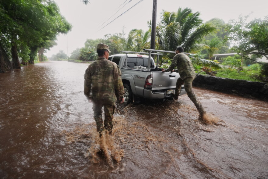 Members of the Hawaii Army National Guard help a resident leave his home as rainwater from nearby Hurricane Nolo floods a section of Māmalahoa Highway Saturday, Sept. 26, 2026, near Naʻālehu, Hawaiʻi Island.