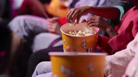 Moviegoers eat popcorn. (Klaus Vedfelt/Getty Images)