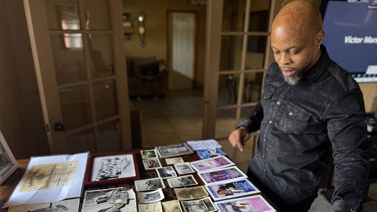 Geryl Dennis neatly organized old photographs, newspaper clippings and brochures on a table. He's collected the items to preserve his family's history.