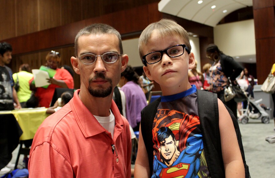 Ronald Zaiger poses with his son Ronald Zaiger Jr. in the resource room at the Back-to-School Store. Zaiger picked up three gun locks to keep his son, 5, and daughter, 7, safe.