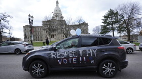A motorist participates during a drive-by rally to certify the presidential election results near the Capitol building in Lansing, Mich., Saturday, Nov. 14, 2020. (AP Photo/Paul Sancya)