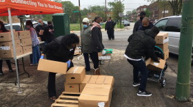Residents of the Auburn-Gresham neighborhood line up for boxes of food at a weekly pop-up food pantry.