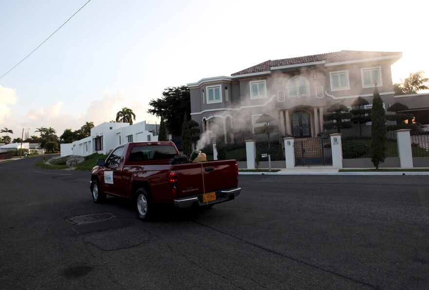 A health department pickup truck sprays insecticide against mosquitoes in a San Juan, Puerto Rico, neighborhood in January.