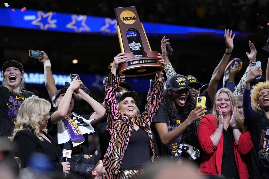 LSU head coach Kim Mulkey holds the winning trophy after the NCAA Women's Final Four championship basketball game against Iowa on Sunday. As coach, Mulkey now has four national titles to her name.