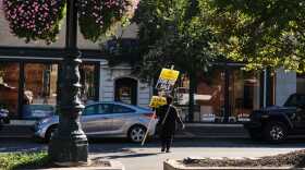 A worker carries a clearance sale sign on the Country Club Plaza.