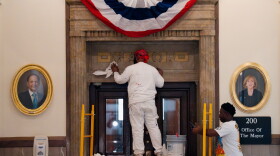 A new study finds "persistent dissatisfaction" among city workers with their pay. Two of them are shown here in April wiping Mayor Tishaura Jones' name from the mayor's office entrance ahead of Cara Spencer's inauguration at City Hall.