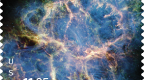 A vivid infrared image of the Crab Nebula showing bright orange and red filaments woven through a glowing blue cloud of gas, with intricate, web-like structures expanding outward into dark space.