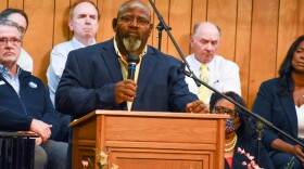 A man stands a podium in a church.