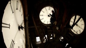 Custodian Ray Keen inspects a clock face before changing the time on the 100-year-old clock atop the Clay County Courthouse, March 8, 2014, in Clay Center, Kansas.