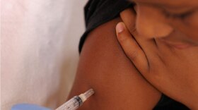 A nurse gives a young boy a vaccination.