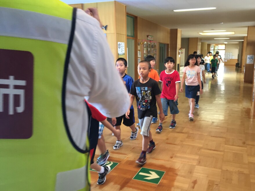 Elementary school students in Iwamizawa, a town in Japan's Hokkaido prefecture, take part in a missile drill.