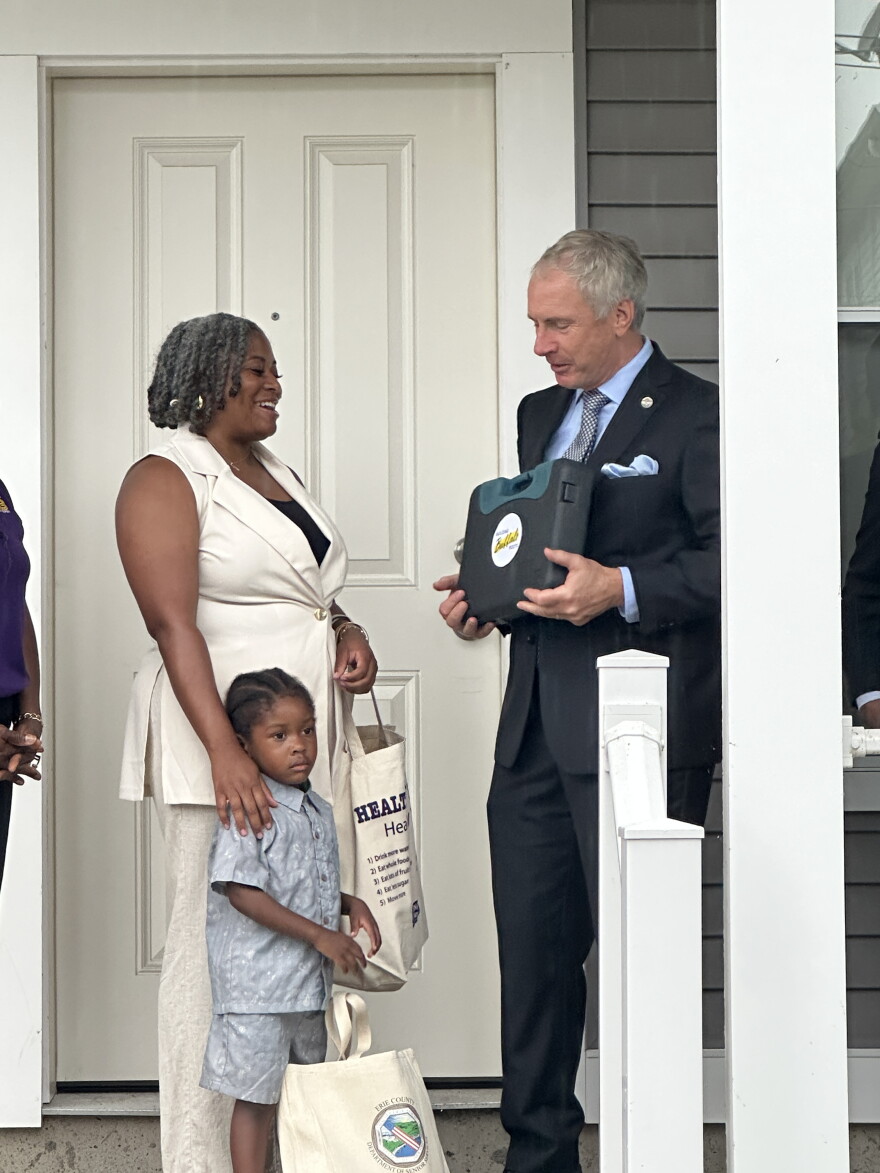 Mayor Sean Ryan presenting the Walton family with a new tool set as a welcome home gift.