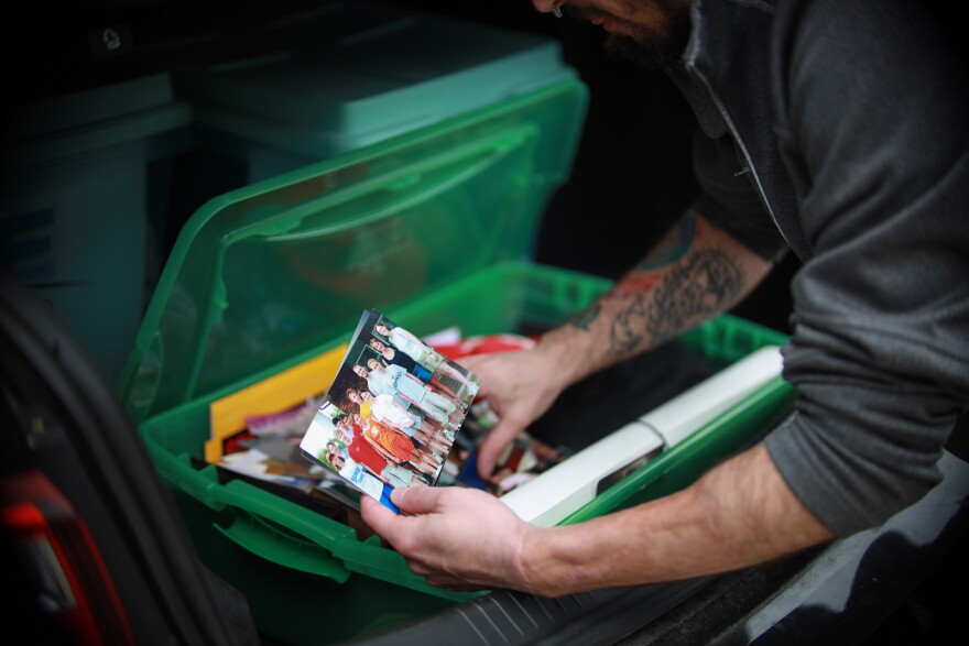 Alexx Abreu gets distracted from packing his car by a box of family photos. Abreu says although his car is small and he can't move all of his belongings in one trip, the photos are a priority. 