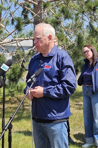 Gov. Tim Walz addresses the press near a residence on the east side of Lake Bemidji on June 24, 2025. Standing at his far right is Beltrami County Emergency Management Director Chris Muller.