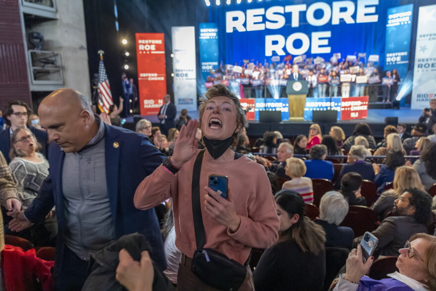 A protester who interrupted President Biden is escorted from the rally at George Mason University in Manassas, Va., on Jan. 23.