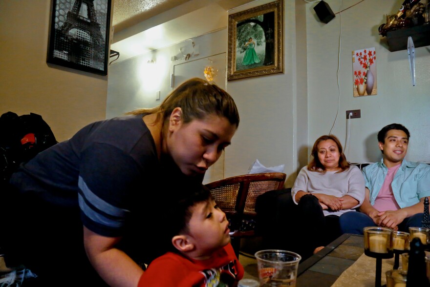 Rosa, second from right, who wants her last name withheld, an undocumented immigrant who used to get about $190 per month from the Supplemental Nutrition Assistance Program, or SNAP, and who stopped taking benefits fearing deportation, is surrounded by her son Edgar, far right, daughter Olga, far left, and grandson Logan at their home during an interview in New York, May 17, 2017. (AP Photo/Bebeto Matthews, File)