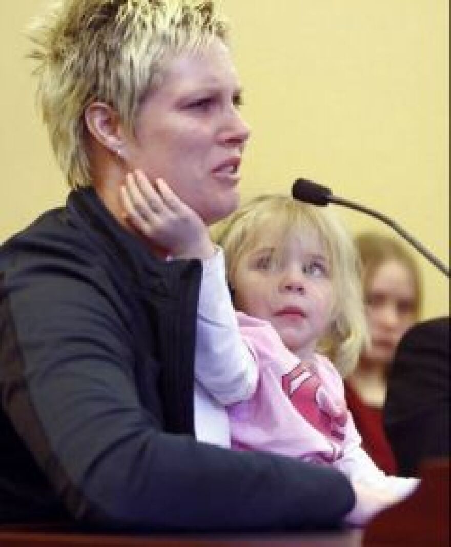 Nicole Wilkinson with her daughter testifies before a senate committee