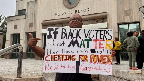 Travis Jackson stands outside the federal courthouse on Friday, May 22, 2026, in Birmingham, Alabama holding a sign in support of Black voters.
