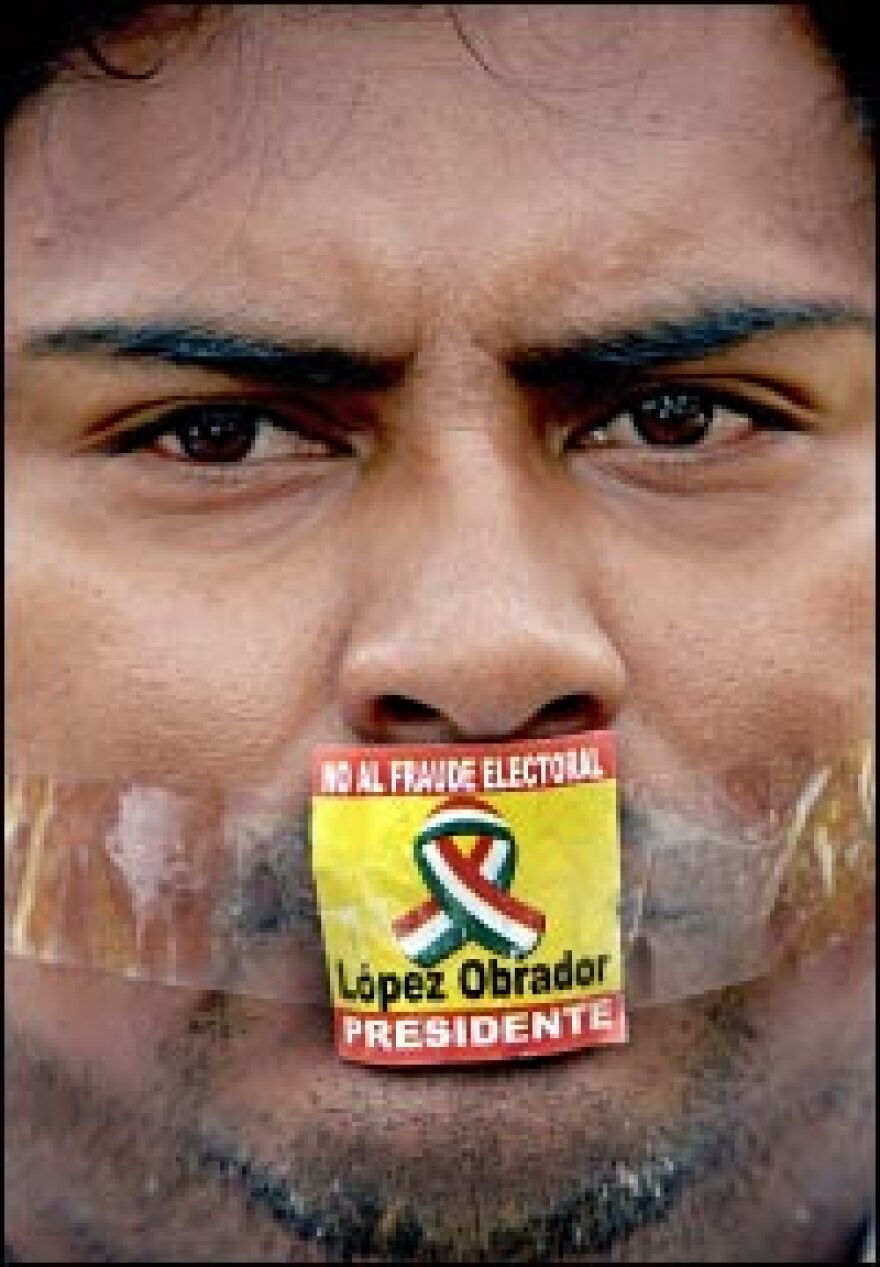 A supporter of defeated Mexican presidential candidate Andres Manuel Lopez Obrador, his mouth taped shut with a sticker that says "No to Electoral Fraud," takes part in a demonstration in Mexico City, August 2006.