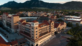 The campus of the University of Colorado Boulder, with tall buildings and red-tiled roofs. 