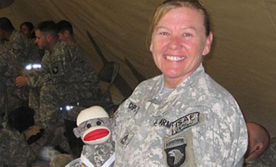 Sgt. 1st Class Candace Chapman poses with her stuffed sock monkey while overseas.