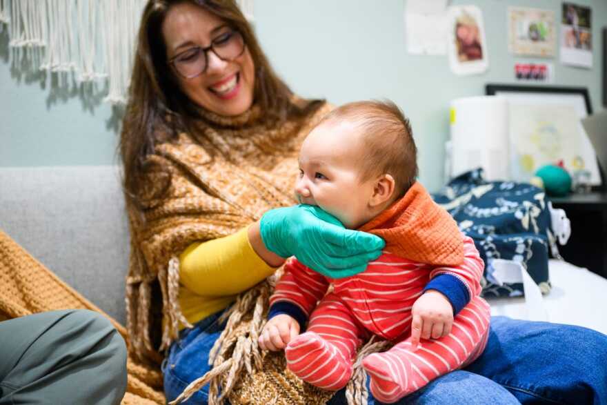 Three-month-old Reuel Wong latches onto lactation consultant Beth Waters’ hand during an appointment at Andaluz Waterbirth Center in Portland, Oregon.
