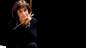 JoAnn Falletta sitting on stage with baton by Cheryl Gorski Photography.