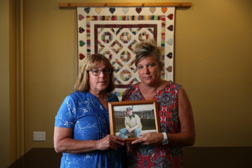 Donna Hart, left, and Sally Tartre hold a photo of their brother, James Roux, who was a passenger on Flight 175, the second plane to hit the World Trade Center towers.