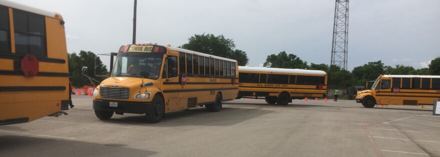 Yellow school buses behind each other in a big lot