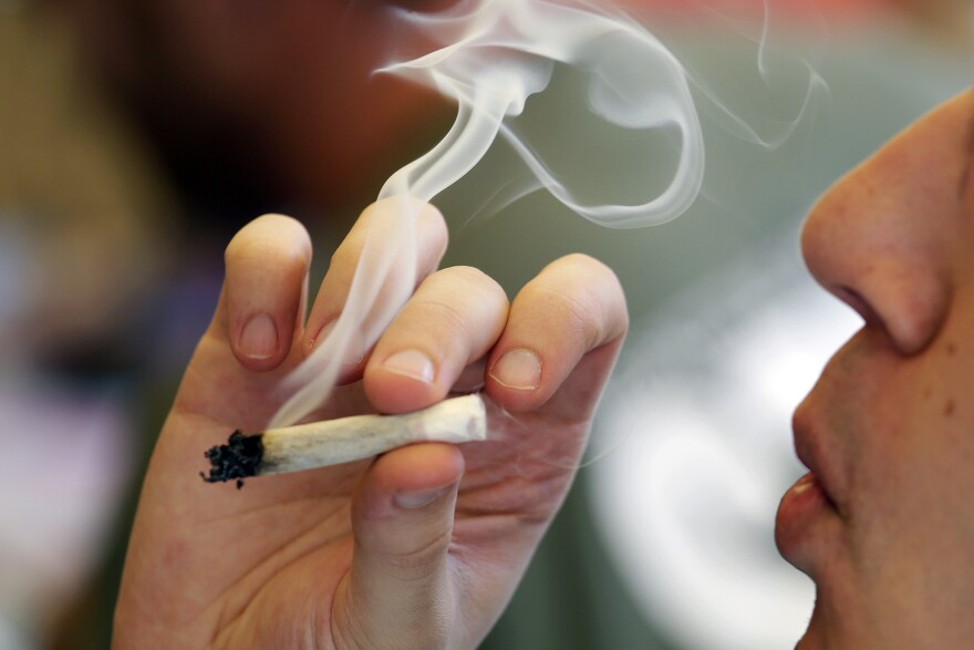 A man smokes a marijuana joint at a party celebrating weed on April 20, 2016, in Seattle.