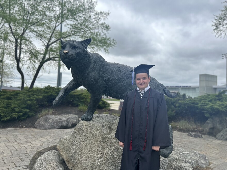 Sam Flynn stands in front of a wildcat on the UNH campus