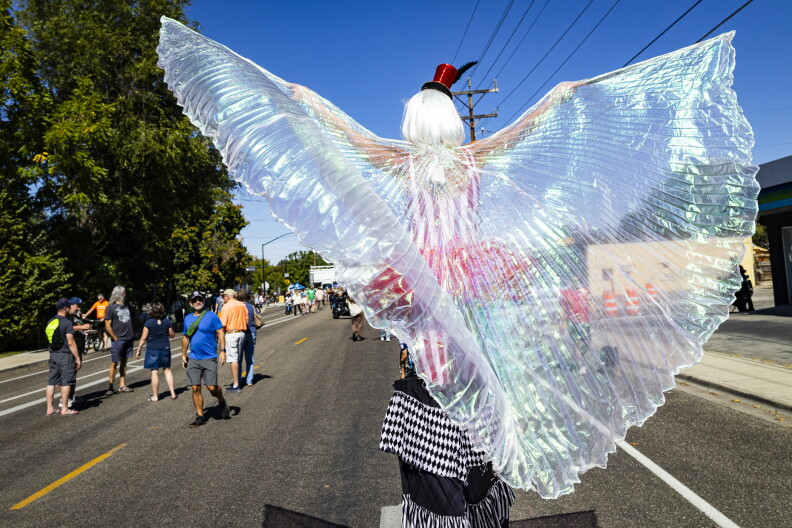 A winged stilt walker makes their way down Latah.