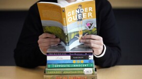 Amanda Darrow, director of youth, family and education programs at the Utah Pride Center, poses with "Gender Queer: A Memoir." (Rick Bowmer/AP)