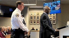 Alachua Executive Liaison and Public Safety and Community Relations Officer Carl Smart provides a proposed direction for the Alachua County Commission on the Gun Violence Prevention Initiative Plan. Standing behind him is county Interim Fire Chief Joseph Shawn Hillhouse. (Jada Ross/ WUFT News)