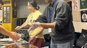 Two UC Riverside students helping serve food at Scotty Eats event. 