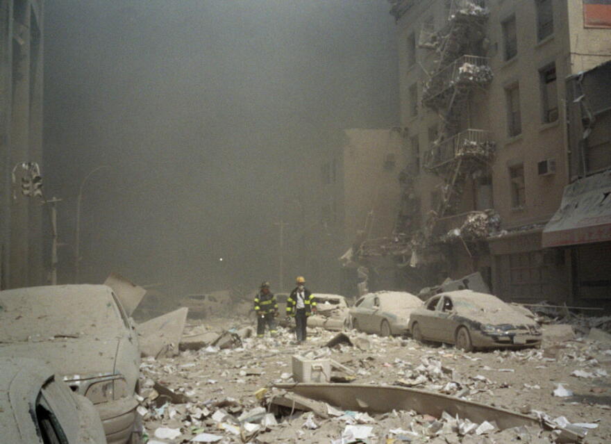 FIremen walk through a dust and debris covered street in lower Manhattan Tuesday, Sept. 11, 2001, after a terrorist attack at the World Trade Center. (Richard Cohen/AP)