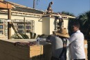 Contractors replace a roof on a Panama City resident's home almost one year after Hurricane Michael devastated the region. 