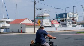 A man rides his bike in downtown Crisfield on April 26, 2025. (KT Kanazawich for The Baltimore Banner)