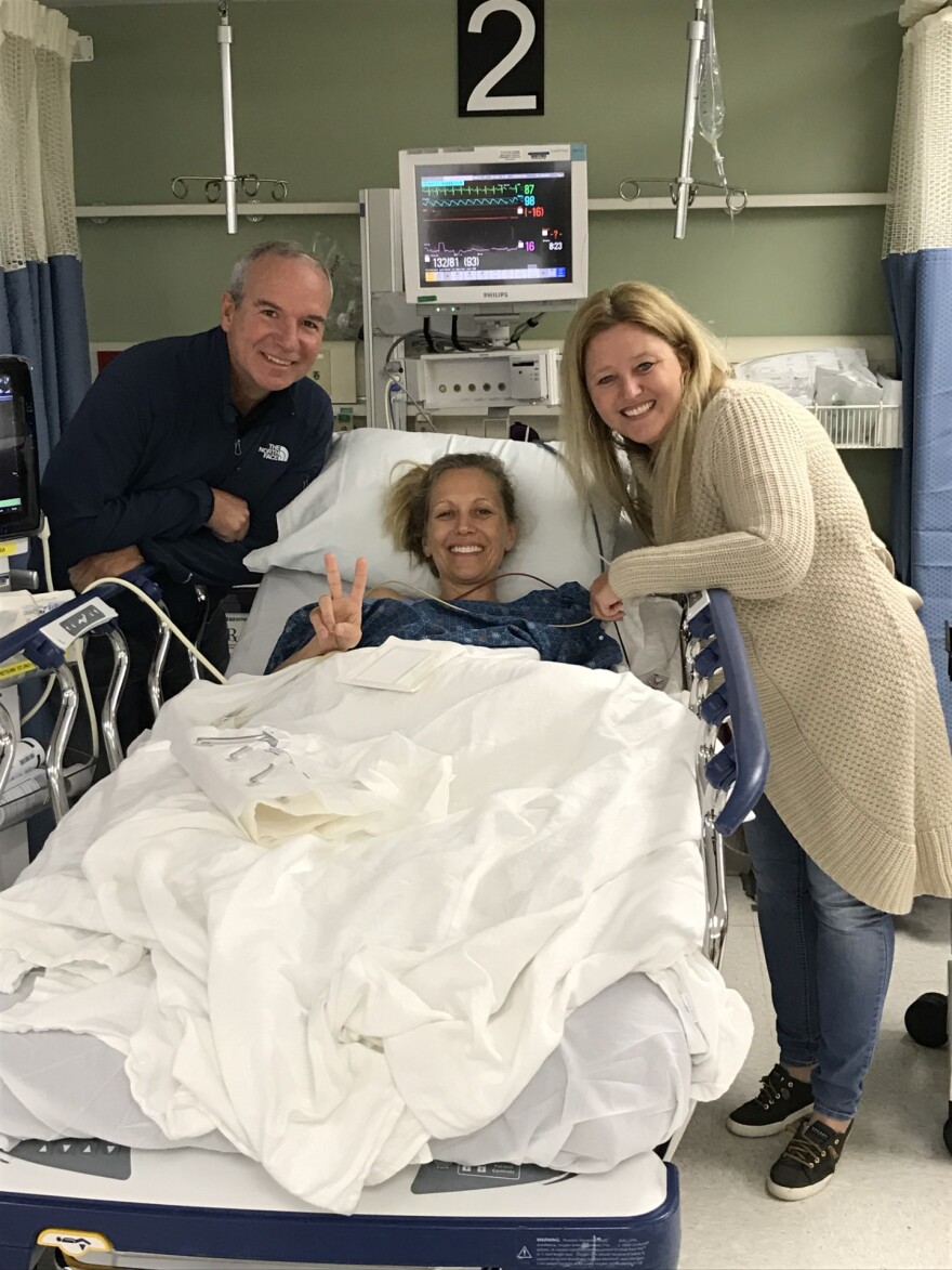Jacquee Wahler of Orlando, sitting in a Central Florida AdventHealth hospital bed. In 2016, she was diagnosed with lung cancer at age 49. A few months later she received surgery to remove the cancerous part of her lungs and has been cancer-free for seven years.