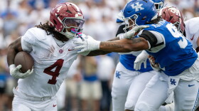 Alabama running back Daniel Hill (4) holds off Kentucky defensive lineman Mi'Quise Humphrey-Grace (90) during the first half of an NCAA college football game, Saturday, Sept. 12, 2026, in Lexington, Ky. (AP Photo/Tony Wagner)
